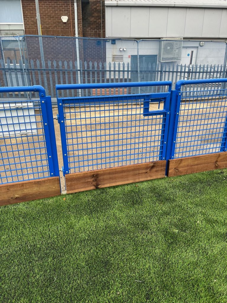 Blue metal fence and grass
